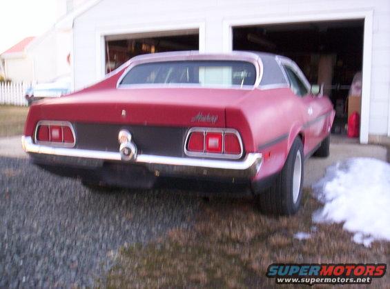 Red 1971 Ford Mustang coupe, rear view, parked in driveway with garage behind
