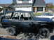 1967 Ford Bronco - Side view of a black 1967 Ford Bronco modified with a roll cage and soft top.