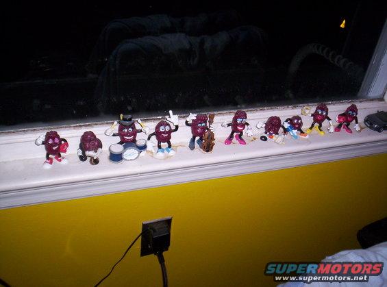 Raisin figures playing instruments and standing on a windowsill with a dark background