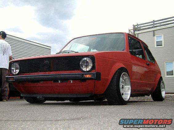 Red Volkswagen Golf Mk1 lowered on aftermarket wheels, front 3/4 view
