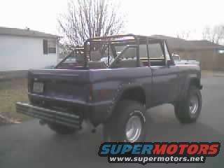 Purple 1978 Ford Bronco with aftermarket roll cage, rear view. Custom bumper
