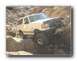 1990 Ford Bronco - This 1990 Ford Bronco is shown tackling a challenging off-road course with steep inclines and large rocks.