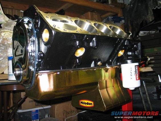 Engine block with gold oil pan and white oil filter attached. Milodon logo visible on oil pan