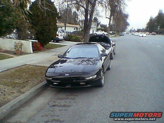 1993 Ford Probe parked on street, hood open on car behind it