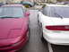 1993 Ford Probe - Two Ford Probe GTs, one red and one white, are parked in a lot.