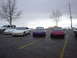 1993 Ford Probe - A trio of Ford Probes, a white, a purple, and a red model, are parked in a lot under an overcast sky.