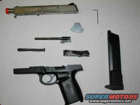 Disassembled pistol with slide, barrel, spring, frame, and magazine on a white surface