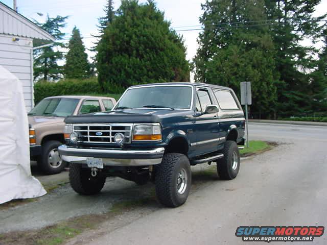Dark blue 1993 Ford Bronco 3/4 front view, lifted with large tires