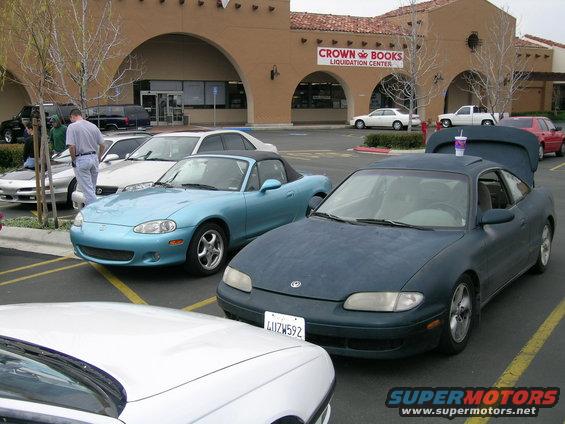 Dark blue coupe with trunk open, front view