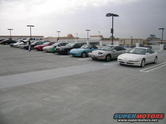 Several 1993 Ford Probes parked in a lot, one white, one silver, and others further back