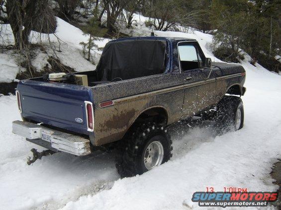 Ford Bronco driving in snow, lifted with big tires