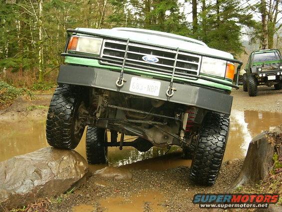 Green 1990 Ford Bronco front view navigating an obstacle course