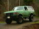 1990 Ford Bronco - Green 1990 Ford Bronco with off-road tires parked on a muddy dirt road.