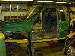 1990 Ford Bronco - A worker in a yellow hard hat examines a green vehicle body during its assembly process.