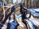 1974 Ford Bronco - An off-road vehicle navigates a challenging muddy and snowy trail in a wooded area.