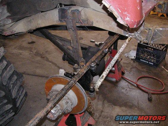 Modified suspension and drivetrain components on a vehicle, with a large tire visible