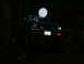 1990 Ford Bronco - A blue pickup truck is seen at night, its headlights illuminating the dark surroundings.