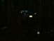 1990 Ford Bronco - A blue SUV navigates a dark, wooded trail at night, its license plate illuminated.