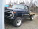 1977 Ford F-250 - This 1977 Ford F-250 pickup truck is shown from the front quarter angle with a flat wooden bed.