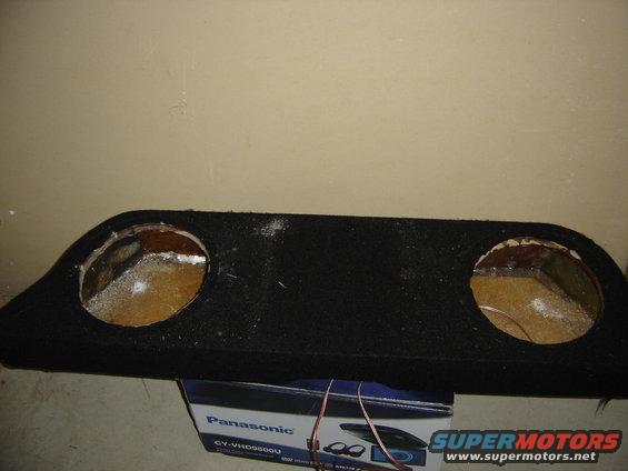 Black fabric-covered enclosure with two circular cutouts, sitting on a Panasonic box