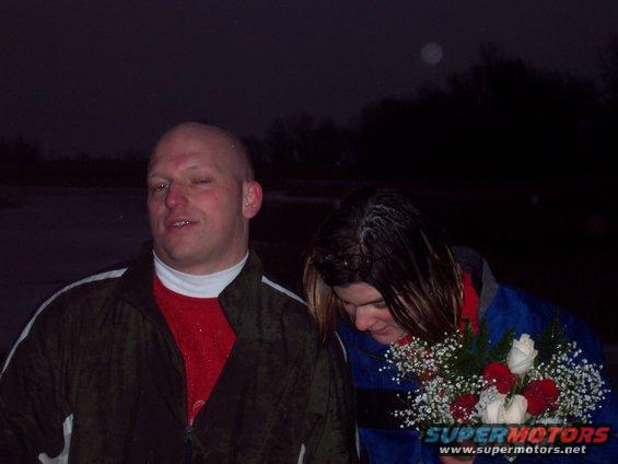 Man and woman with flowers at night. Watermark reads SUPERMOTORS