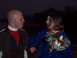 1987 Ford Bronco - A man and woman stand close together outdoors at night, with the woman holding a bouquet of flowers.