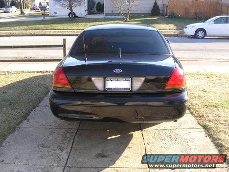 Rear view of a black Ford Crown Victoria parked on a driveway. License plate is visible
