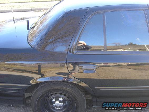 Black sedan rear quarter panel and door, steel wheels, tinted windows