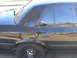 1999 Ford Crown Victoria - Side view of a black sedan with steel wheels and tinted windows.