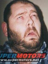 Man with eyes rolled back, wearing a plaid shirt. Text overlay reads SUPER MOTORS www.supermotors.net