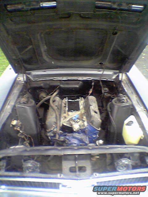 1968 Ford Mustang engine bay with hood open, blue engine block