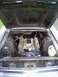 1968 Ford Mustang - The engine bay of a 1968 Ford Mustang is visible with the hood raised, revealing the engine block painted blue.