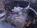 1985 Ford Bronco - Close-up view of a vehicle's engine bay, highlighting the carburetor and various engine components.