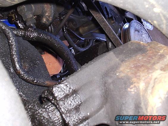 engine bay with greasy hoses and metal parts, possibly near oil filter