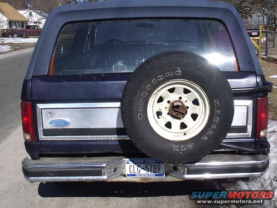Rear view of a 1985 Ford Bronco with a spare tire and New York license plate