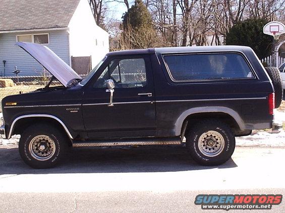 1985 Ford Bronco parked outside with hood open. Side view