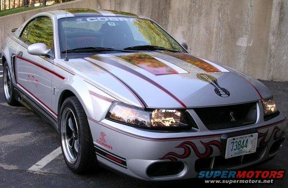 Silver 2003 Ford Mustang Cobra with red racing stripes and flame decals on the front bumper