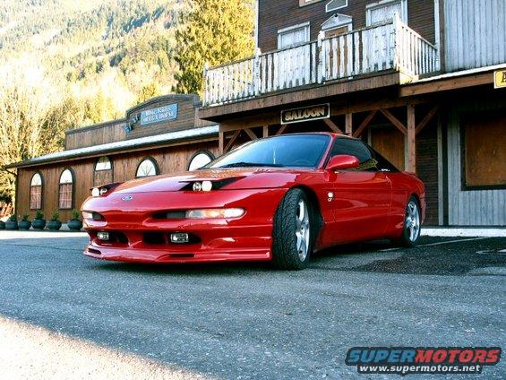 Red 1994 Ford Probe parked in front of a saloon