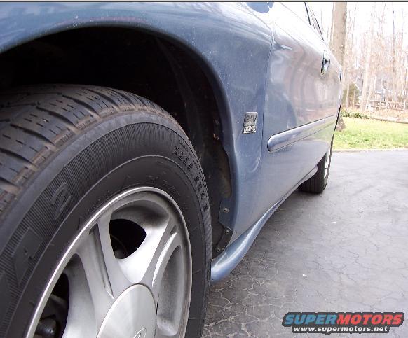 1999 Ford Taurus side view showing front wheel and door badge