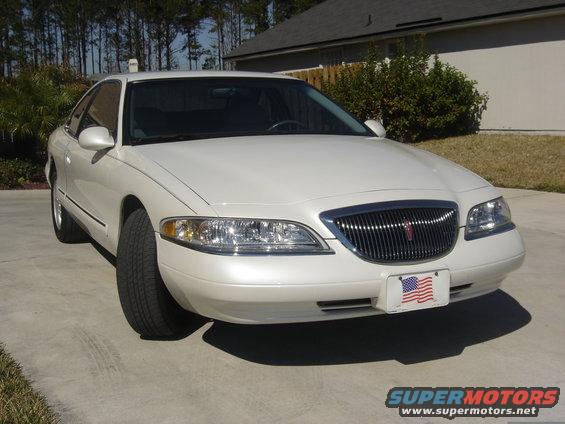 White 1997 Lincoln Mark VIII coupe parked on concrete driveway, front 3/4 view