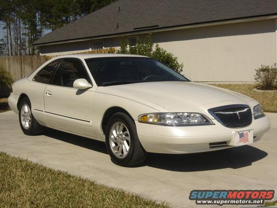 White 1997 Lincoln Mark VIII coupe parked on a concrete driveway, front 3/4 view