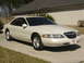 1997 Lincoln Mark VIII - A white 1997 Lincoln Mark VIII coupe is shown from the front 3/4 angle on a sunny day.