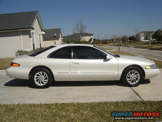 White 1997 Lincoln Mark VIII coupe parked on a driveway, side view