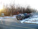 1979 Ford Bronco - A line of vehicles is parked on a snow-dusted road near a wooded area, with a sign for Paragon Adventure Park in the background.