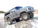 1979 Ford Bronco - This modified Ford Bronco is shown off-road on a rocky, snow-dusted surface.
