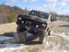 1979 Ford Bronco - Ford Bronco tackles a challenging off-road course with multiple vehicles present.
