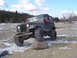 1979 Ford Bronco - A Jeep CJ-5 navigates an off-road course with a rock in its path.
