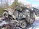 1979 Ford Bronco - A camouflaged Jeep Wrangler navigates a challenging snowy and rocky terrain, with another vehicle visible in the background.