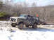 1979 Ford Bronco - Ford Bronco navigates a snowy, wooded terrain with an orange flag on its antenna.