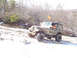 1979 Ford Bronco - A driver navigates a muddy Jeep over a snowy and rocky off-road path.
